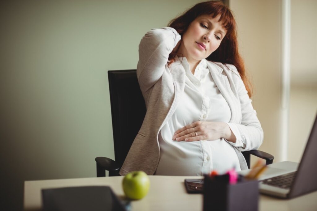 Back pain during pregnancy in USA – pregnant woman holding lower back